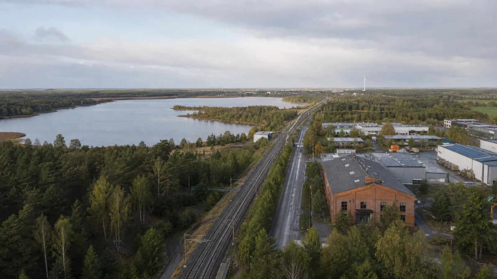 Symbolisches Luftbild einer Lausitzer Wirtschaftslandschaft mit See, Bahnstrecke und Gewerbebetrieben